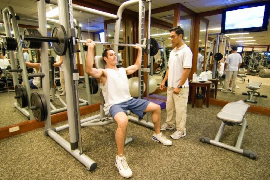 Hotel Marco Polo Davao Stadt Exterior foto A personal trainer assisting a client with a weight training exercise